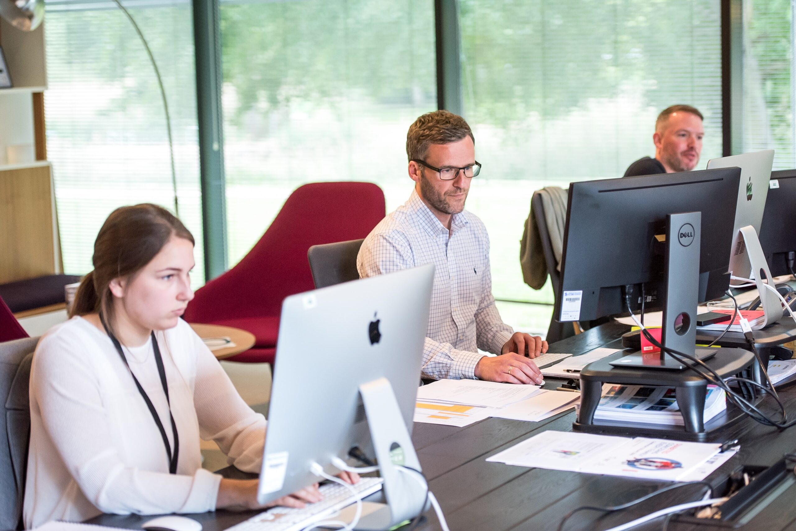 Various people working at computers, some on macs, some on pcs